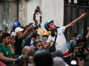 A Lebanese protester hurls a stone at security forces amid clashes in downtown Beirut on August 11, 2020, following a huge explosion that devastated large parts of the capital.