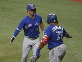Toronto Blue Jays center fielder Randal Grichuk is congratulated on his three run home run by third baseman Vladimir Guerrero Jr.  during the seventh inning against the Tampa Bay Rays at Tropicana Field.
