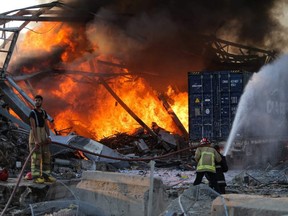 Firefighters douse a blaze at the scene of an explosion at the port of Lebanon's capital Beirut on Tuesday, Aug. 4, 2020.