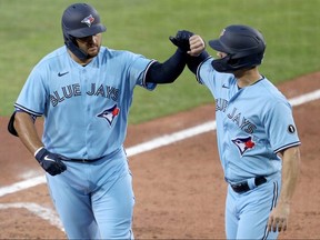 Rowdy Tellez of the Toronto Blue Jays celebrates with teammate Randal Grichuk after hitting a home run against the Miami Marlins at Sahlen Field on August 12, 2020 in Buffalo.