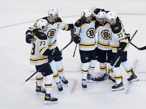 Boston Bruins players celebrate a goal against the Tampa Bay Lightning during Game 1 of their playoff series on Sunday.