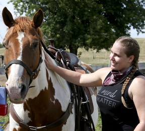 Victoria Henri enjoys a few moments with the horses after a trail ride at Pathways on Pleasure Valley. Veronica Henri/Toronto Sun