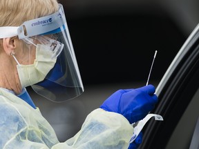 A health-care workers does testing at a drive-thru COVID-19 assessment centre at the Etobicoke General Hospital in Toronto on Tuesday, April 21, 2020.