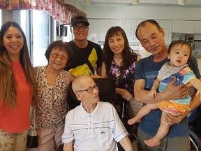 Minh Do, 88 (front), is surrounded by family members.