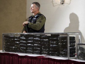 OPP officers guard 55 kilograms of cocaine during a press conference in Barrie, April 3, 2019. Federal prosecutors are being instructed to criminally prosecute only the most serious drug possession offences and to find alternatives outside the criminal justice system for the rest.