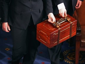 Senate pages carry bound wooden boxes containing the Electorial College votes from the 50 states into the House of Representatives chamber at the U.S. Capitol January 4, 2013 in Washington.