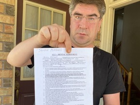 Tenant Mikhail Shubin shows his rental contract he signed ten years ago.
