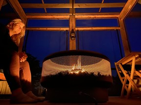 A propane fire pit inside the screened-in area of the Pine Brae cabins makes for a relaxing place to wind down under the stars, just as Sara is doing here. IAN SHANTZ/TORONTO SUN