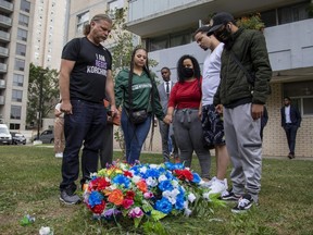 Regis Korchinski-Paquet's father, Peter Korchinski, sister Renee Korchinski, lawyers Knia Singh and Silvia Argentina Arauz, brother Reece Korchinski and first cousin Tyrell Beals say a prayer around a memorial in Toronto on Wednesday, August 26, 2020.