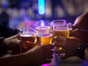 Group of  young people hands toasting and cheering aperitif beers half pint