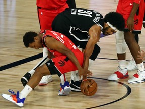 Raptors guard Kyle Lowry (left) battles for a loose ball with Jarrett Allen of the Brooklyn Nets during the first quarter of Game 4 on Sunday. Lowry had to leave the game with what has been diagnosed as a sprained ankle.
