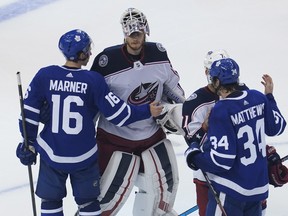 Maple Leafs forward Mitch Marner (16) and forward Auston Matthews (34) congratulate Blue Jackets goaltender players after Columbus knocked off Toronto in their Eastern Conference play-in series on Sunday night.
