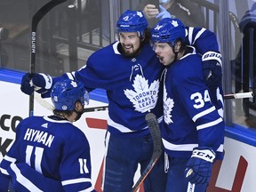 Maple Leafs centre Auston Matthews (34) celebrates his goal with teammates Justin Holl (3) and Zach Hyman after scoring against the Columbus Blue Jackets in the second period of their NHL Eastern Conference play-in game on Tuesday.