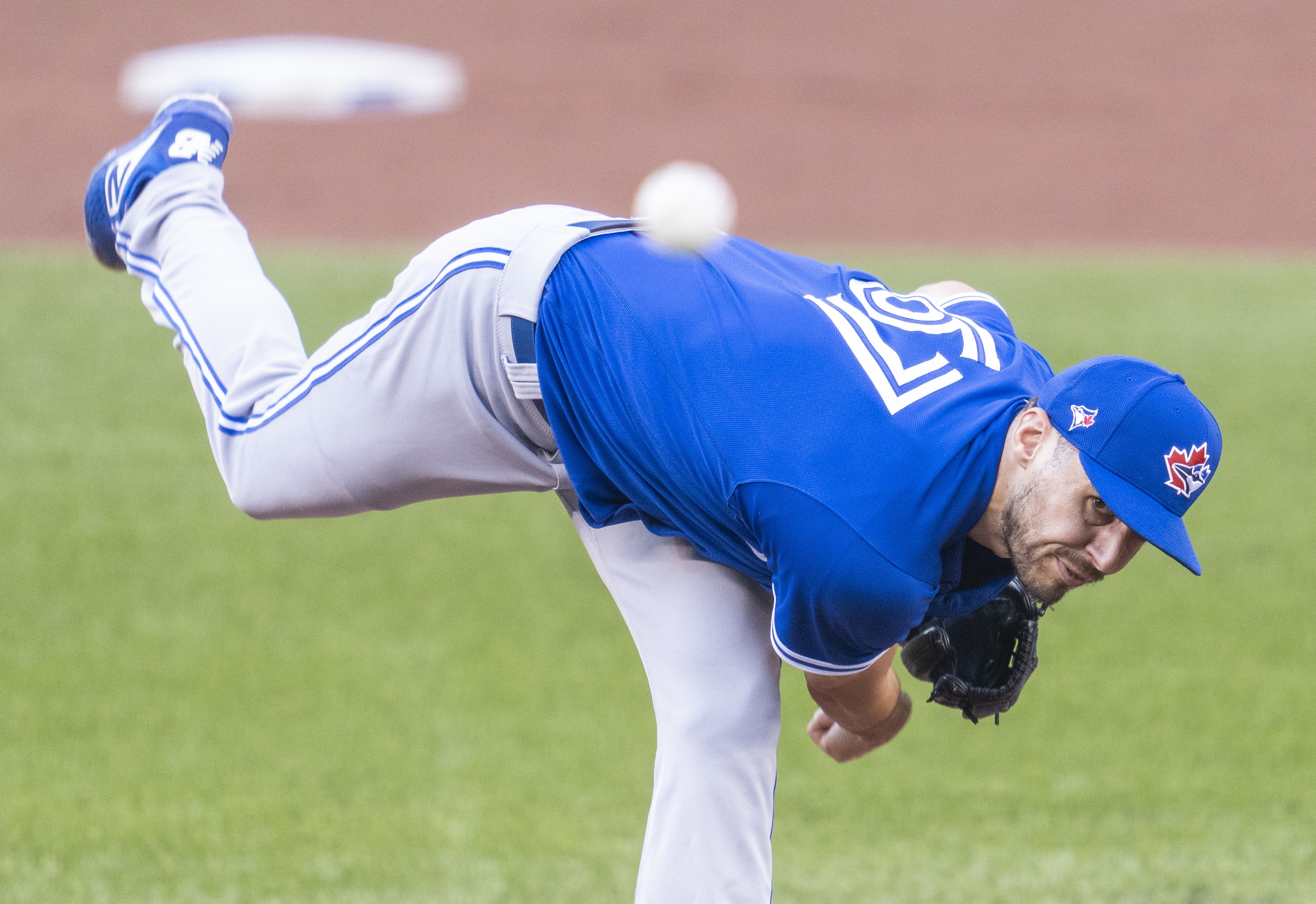 What's the deal with the pitcher's arm at around 28 seconds? Why does he  let it lag behind his elbow instead of keeping it straight? Does doing that  make the ball fly