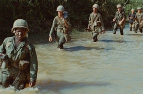 American soldiers advance through a rice paddy during the Vietnam War.