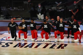 Coach Nick Nurse (left) and Raptors players kneel during the national anthem before Game 4 against the Nets in Lake Buena Vista, Fla. The Raps’ playoff run re-starts Sunday afternoon.