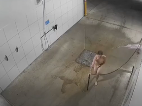 Surveillance video captures a man bathing himself at an Australian car wash.