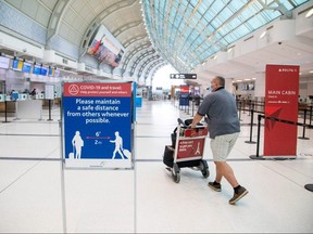 A man pushes a baggage cart wearing a mandatory mask as a "Healthy Airport" initiative is launched for travel, taking into account social distancing protocols to slow the spread of the coronavirus disease (COVID-19) at Toronto Pearson International Airport June 23, 2020.