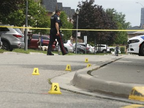 Evidence markers dot the scene of a shooting on Huntington Ridge Dr. southeast of Mavis Rd and Eglinton Ave. W. where a man in his 20s was shot in the head during a melee outside a residence at 9:30 p.m. Monday night.