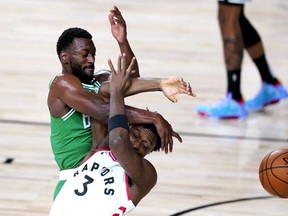Boston Celtics’ Kemba Walker, and Toronto Raptors’ OG Anunoby compete for the ball last night in Lake Buena Vista, Fla. AP