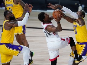 Raptors’ Kyle Lowry drives to the basket against L.A. Lakers J.R. Smith (right) in Lake Buena Vista, Fla., last night.  Getty Images