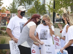Family members Kazimierz Lugiewicz (L) and his wife Lilianna (wiping away tears) along with supporters listen to their phones outside Brampton court as bail was denied for Brady Robertson, 20. He is accused in the deaths of their daughter Karolina Ciasullo, 37, and her three daughters - Klara, 6, Lilanna, 3, and Mila, 1 during a multi-car collision on June 18 at the intersection of Torbram Rd and Countryside Dr. on Friday, Aug. 21, 2020.