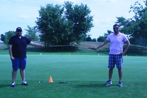 Brothers Vaneet Handa (left) and Rohit Handa demonstrate how the length of two golf clubs provides about six feet of physical distancing during a lesson for golf beginners at Mayfield Golf Club in Caledon East, Ont.