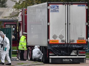 In this file photo taken Oct. 23, 2019, British Police forensics officers work on a lorry, found to be containing 39 dead bodies, at Waterglade Industrial Park in Grays, east of London.