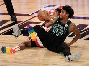 Raptors' Kyle Lowry and Celtics' Marcus Smart wrestle for a loose ball during Tuesday's game.