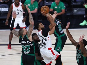 Toronto Raptors guard Norman Powell shoots against several Boston Celtics defenders.