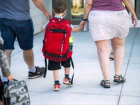 Ottawa — August 19, 2020 — Brody Lafrance, who was starting senior kindergarten, walks with his parents to the front door, before heading into his classroom. Students were welcomed back for the first day of school at  Elementary School Catholic Jonathan-Pitre, Wednesday, August 19, 2020. ASHLEY FRASER, POSTMEDIA