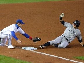 DJ LeMahieu of the New York Yankees slides safely into third base as Cavan Biggio of the Toronto Blue Jays misses the tag during the fifth inning at Sahlen Field on September 22, 2020 in Buffalo, New York.