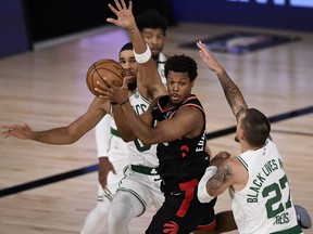 Kyle Lowry, centre, of the Toronto Raptors passes the ball as Daniel Theis, right, of the Boston Celtics defends during the third quarter in Game 4 of the Eastern Conference Second Round during the 2020 NBA Playoffs at the Field House at the ESPN Wide World Of Sports Complex on Sept. 5, 2020 in Lake Buena Vista, Fla.