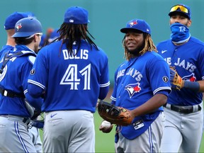Rafael Dolis, second from left, and Vladimir Guerrero Jr., second from right, of the Toronto Blue Jays celebrate after the Blue Jays defeat the Boston Red Sox 10-8 at Fenway Park on Sept. 6, 2020 in Boston, Mass.
