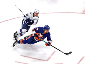 Brock Nelson of the New York Islanders gets tripped up by  Ondrej Palat of the Tampa Bay Lightning during  Game 4 on Sunday in Edmontron