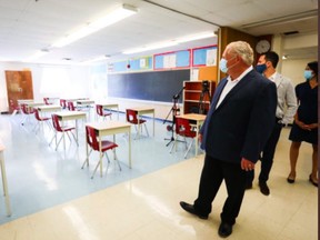 Premier Doug Ford  and Education Minister Stephen Lecce (behind)  toured Kensington Community School in Toronto on Sept. 1 to see what safety measures were in place for COVID-19.