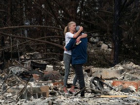 Christina Mitchell embraces her fiance, George Schmoll, amidst the remnants of their apartment after losing items such as her wedding dress and his wedding ring for their December wedding, now postponed, after a wildfire came through the area in Phoenix, Oregon, Sept. 18, 2020.