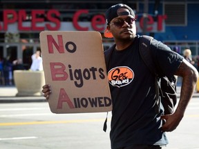 A man carries a message as people gathered to protest outside Staples Center prior to Game 5 of the first-round NBA playoff game between the Los Angeles Clippers and the Golden State Warriors, April 29, 2014 in Los Angeles, California.