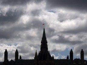 Clouds pass by the parliament buildings on Aug. 19, 2020, in Ottawa.