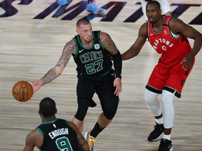 Boston Celtics centre Daniel Theis (27) passes the ball to guard Brad Wanamaker (9) against Toronto Raptors centre Serge Ibaka (9) during the second half of Game 5 of the second round in the 2020 NBA Playoffs at ESPN Wide World of Sports Complex on Sept. 7, 2020.