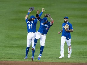Blue Jays' Bo Bichette , Jonathan Villar and  Teoscar Hernandez (right) celebrate after clinching a playoff spot following a victory over the New York Yankees at Sahlen Field.