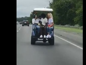 A screengrab from video shows women using a golf cart on a U.S. highway.