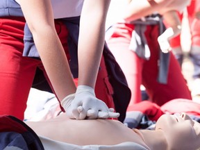 A paramedic demonstrates CPR on a dummy.