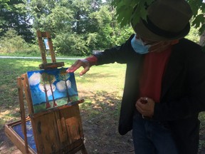 Professional artist-instructor Andrew Cheddie Sookrah critiques Jane Stevenson’s painting on the grounds of the McMichael Canadian Art Collection gallery.
