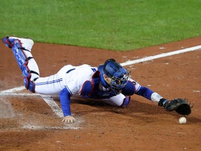 Danny Jansen of the Toronto Blue Jays dives for the ball after missing a play at the plate against the New York Mets at Sahlen Field on September 11, 2020 in Buffalo.