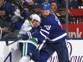 Canucks forward Tyler Toffoli, left, gets hammered by Leafs forward Kyle Clifford, right, during NHL action at Scotiabank Arena in Toronto, Feb. 29, 2020.