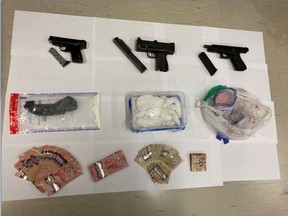 A photo released by Toronto Police of firearms, drugs and cash seized in the execution of search warrants on Sept. 22, 2020. Salim Slammy, 27, of Toronto, faces numerous charges.