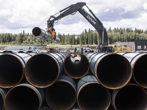 Pipe for the Trans Mountain pipeline is unloaded in Edson, Alta. on Tuesday June 18, 2019.