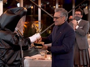 This handout picture shows Canadian actor Eugene Levy receiving his Emmy while his son actor/director/writer Daniel Levy watches during the 72nd Primetime Emmy Awards ceremony held virtually on Sunday, Sept. 20, 2020.
