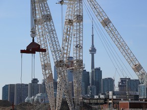 The downtown skyline and CN Tower are seen past cranes in Toronto.